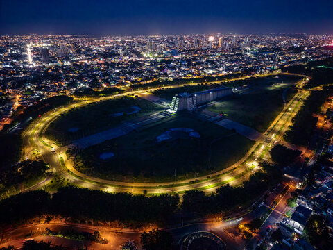 Aerial view of the illuminated Columbus Lighthouse surrounded by a circular park and city lights at night in Santo Domingo Este, Santo Domingo, Dominican Republic.