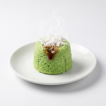Traditional Indonesian Kue Putu Steamed Rice Cake with Palm Sugar and Grated Coconut on White Plate