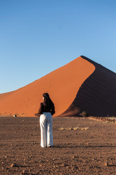 vertical Woman exploring Namib Desert in Sossusvlei, Namibia