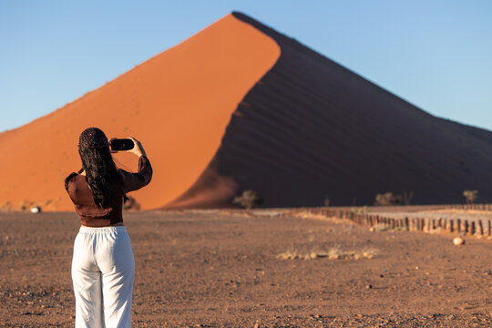 Traveler photographing Sossusvlei sand dune in Namibia desert