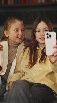 Two girls record video for social media on cellphone, young bloggers