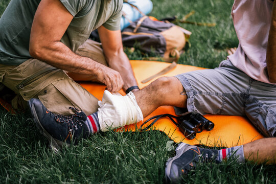 Close up of a hiker's ankle being wrapped with a bandage outdoors