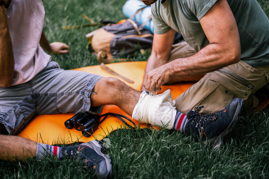Close up of a hiker receiving a bandage for an injured ankle