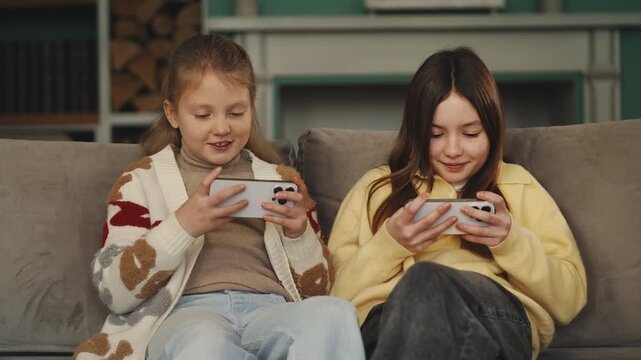 Girls play on their phones, childhood technology addiction concept