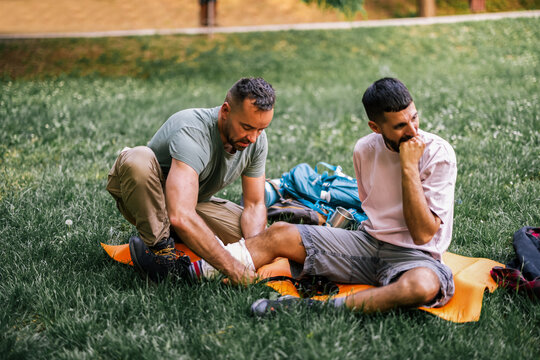 Two hikers resting together after an outdoor injury while one provides care