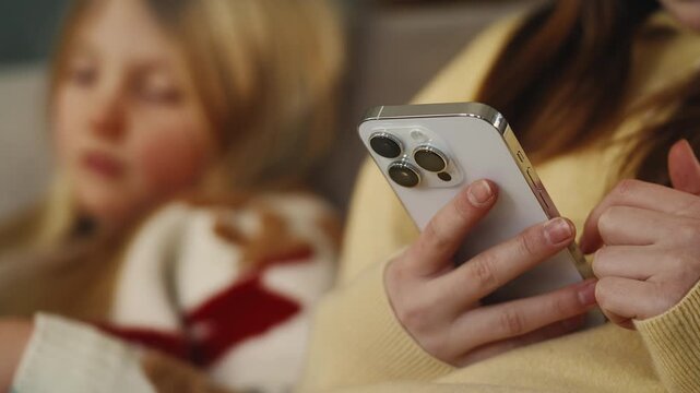 Girls scroll through social media apps on their phones, gadget addiction concept