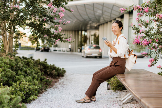 Korean woman enjoys a sunny afternoon while checking her phone