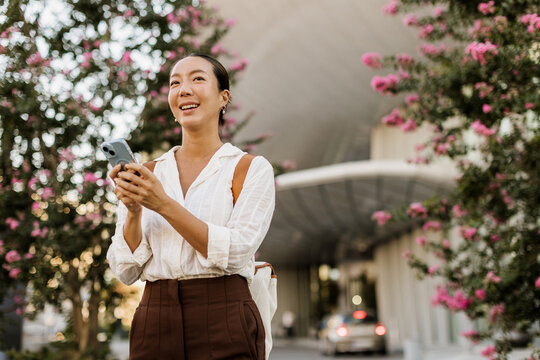Bright smiles as a Korean woman enjoys a sunny day surrounded by flowers