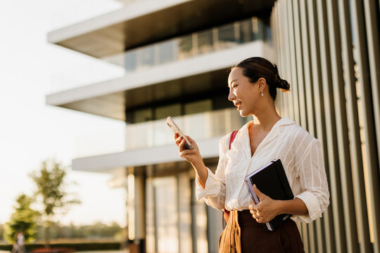 Young professional enjoying her time outside a modern office building