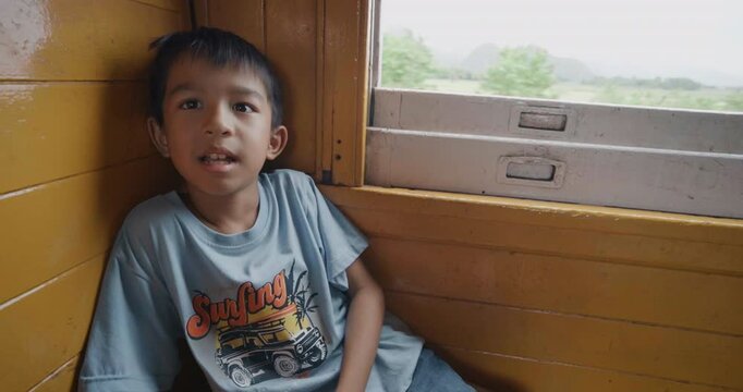 Little asian boy enjoy travel in local old train backpacker kids Thailand