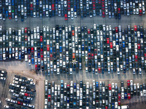 Aerial view of a car storage yard with rows of parked vehicles arranged on an asphalt lot in Settimo Torinese, Piedmont, Italy.