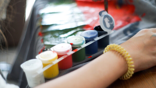 Creative mess with messy paint brushes and multi-colored paints on artist tabletop