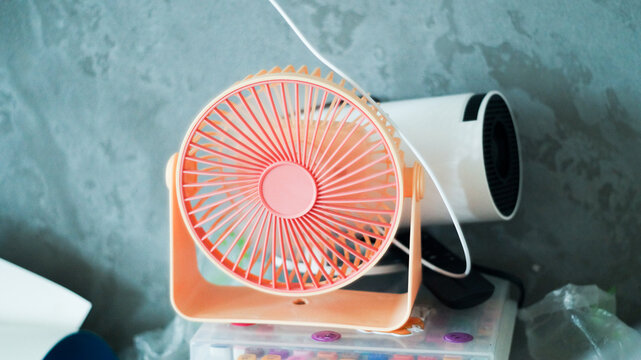 Portable mini USB fan blowing fresh air on office desk workspace