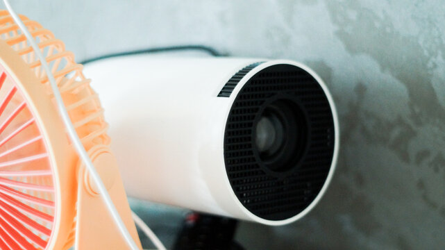 White mini portable projector for watching movies at home cozy interior