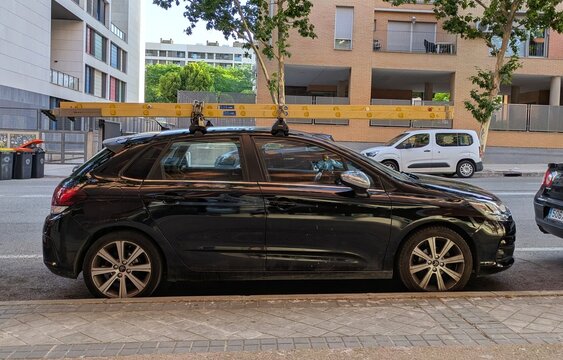 Vista lateral de un autom&oacute;vil Citro&euml;n C4, con una escalera de mano de madera en el portaequipajes de techo, aparcado en una calle de Madrid, Espa&ntilde;a, 11 de junio de 2026