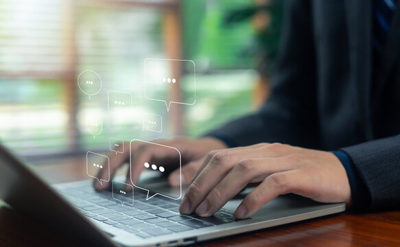 Person using laptop and smartphone with floating social media chat icons, representing online communication, engagement, messaging, and modern digital interaction across platforms.