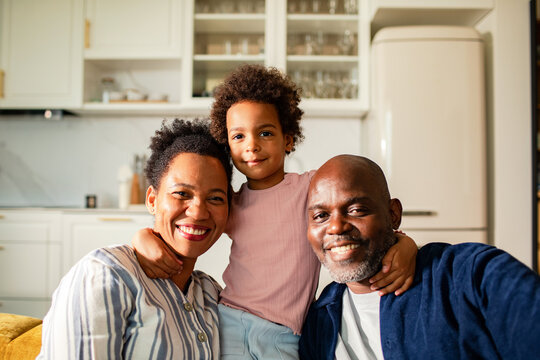 Family of three smiling in home kitchen
