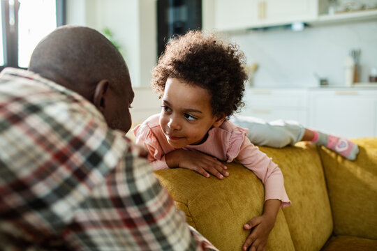 Father and daughter bonding on cozy sofa at home