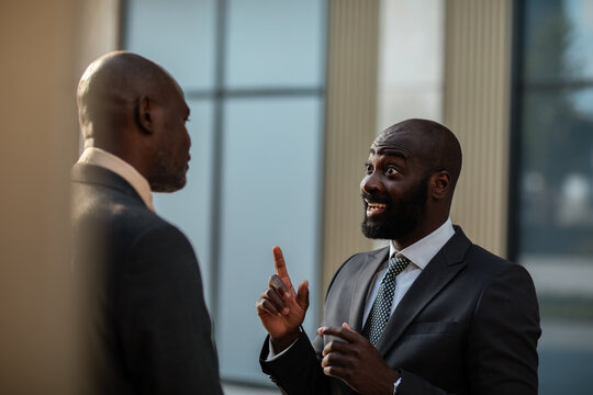 Two businessmen having an animated conversation outside an office building