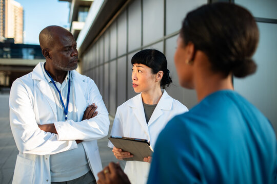 Doctors and nurse discussing patient care outside hospital