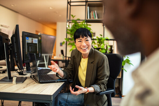 Smiling businesswoman discussing project in modern office