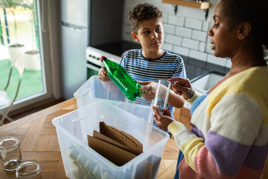 Mother and son sorting recycling in kitchen