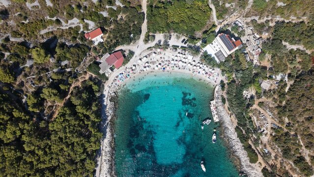 Crique anim&eacute;e aux eaux turquoise et parasols sur les &icirc;les Pakleni, Hvar, Croatie