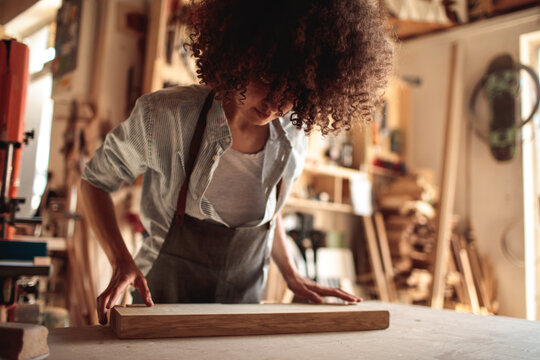 Craftsperson measuring wooden plank in workshop