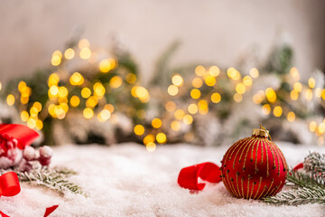 Naklejka premium A Christmas background featuring red baubles with golden glitter stripes, a star, and ribbon framing wide snowy ground, softly lit by warm twinkling lights with generous copy space.