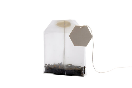 Single tea bag with a blank paper label tag for herbal drink isolated on transparent background