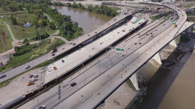 Aerial view of interstate 70 west and east moving near downtown Columbus, Ohio as newly opened roadway infrastructure with car traffic drives along underpass as construction on new highway continues