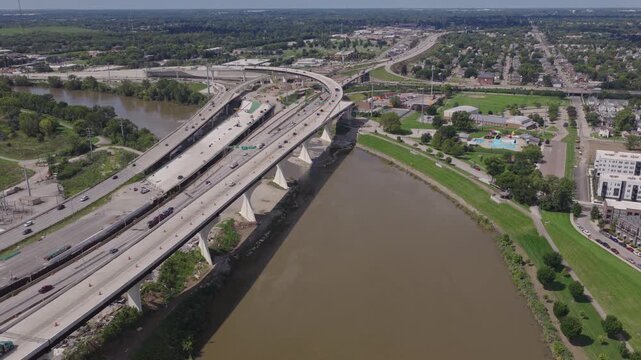 Aerial view of interstate 70 west and east moving near downtown Columbus, Ohio as newly opened roadway infrastructure with car traffic drives along underpass as construction on new highway continues