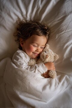 Adorable little child sleeping in bed and cuddling a soft teddy bear, having sweet dreams