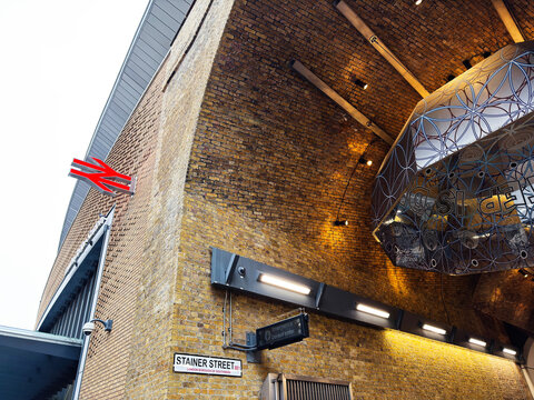 Stainer Street railway entrance under brick arch with National Rail sign in London, UK, contemporary station architecture and illuminated canopy