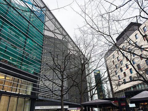 Modern commercial architecture and street shopping scene with M&S Simply Food storefront and business offices in London, UK