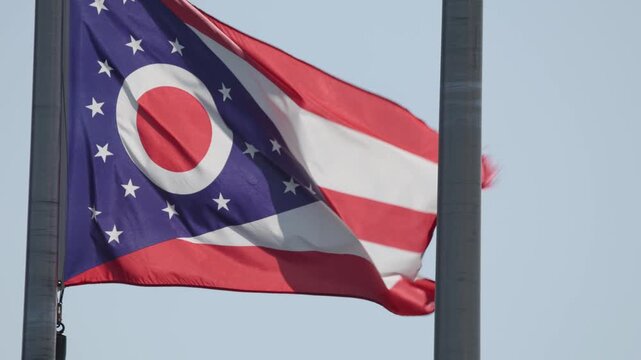 The Burgee flag of Ohio, a red, white, and blue U.S. flag with a triangular swallowtail shape in slow motion slo mo close up on pole swaying in wind slowly in color 4k