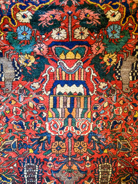 Antique Persian wool rug with detailed floral vase pattern