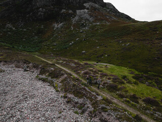 Fototapeta premium Hikers in the rough terrain of Glen Etive