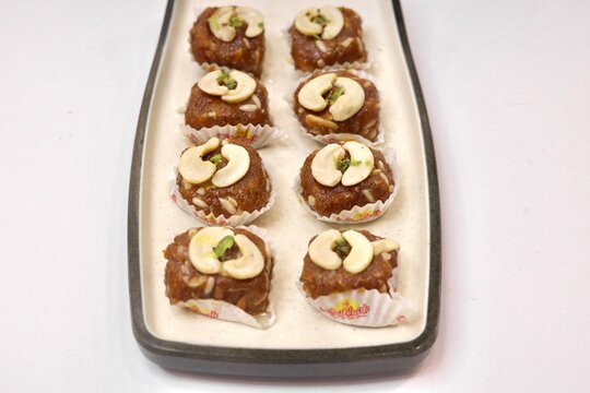 Dodha barfi garnished with cashews on a white plate