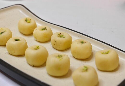 Peda sweet garnished with pista on white plate