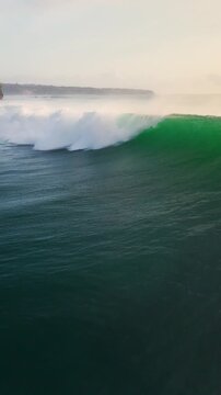 Drone view with breaking ocean waves in ocean in Bali