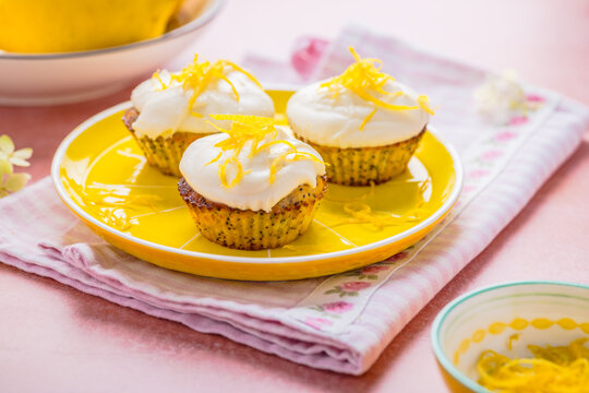 Delicate poppy seed lemon cupcakes topped with fluffy white frosting and zest