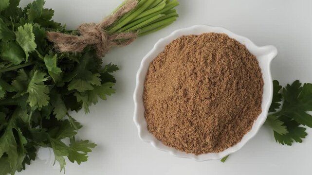 Fresh coriander leaves and ground powder spice on white background