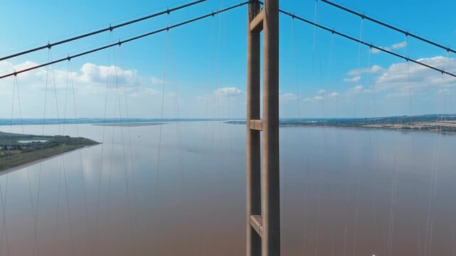 Massive bridge spans wide river under clear blue sky