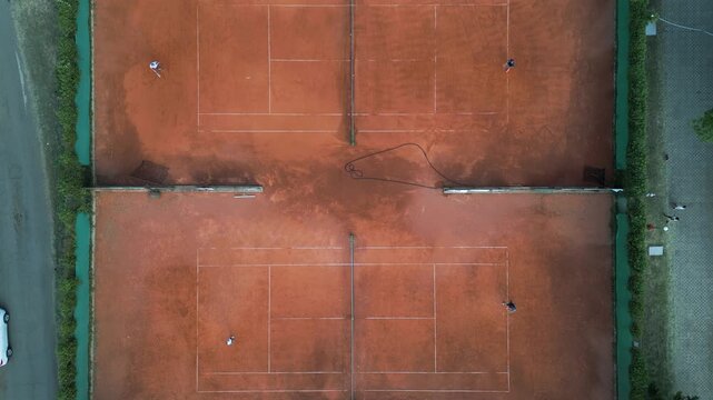 Aerial Top-Down View of Clay Tennis Courts with Players During Match