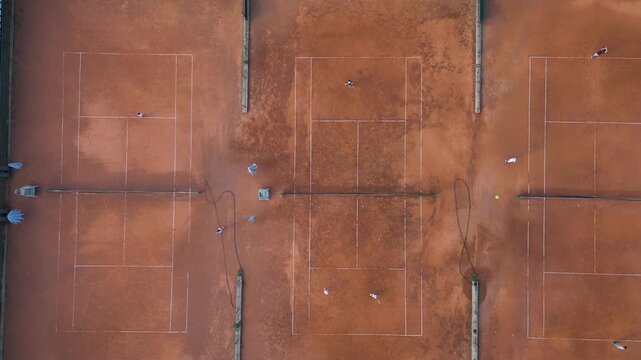 Aerial Top-Down View of Clay Tennis Courts with Players During Match