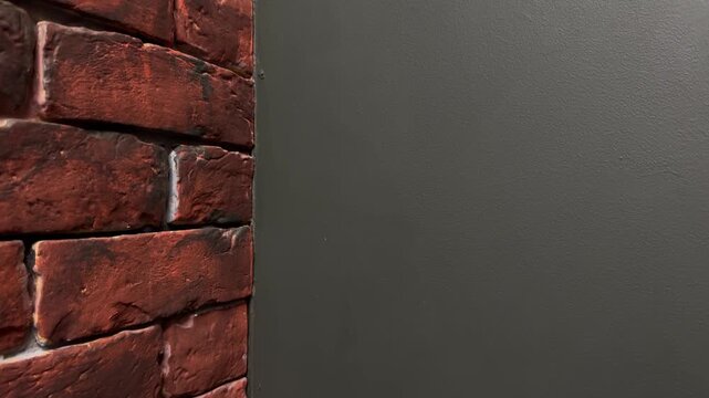 Slow top to bottom camera movement along brick wall and dark surface with copy space, minimalist architectural texture, vertical video