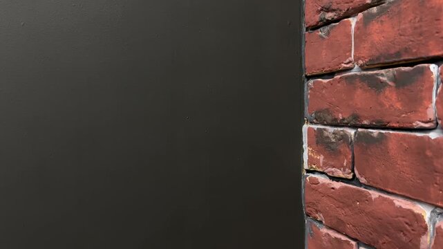 Slow top to bottom camera movement along dark wall and red brick corner with copy space, minimalist architectural background, vertical video