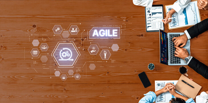 A modern office environment featuring professionals collaborating around a table, utilizing technology to enhance agile project management and productivity. Trope