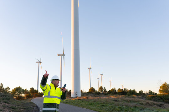 Renewable energy engineer managing wind turbines, working at a wind farm generating clean power and green electricity